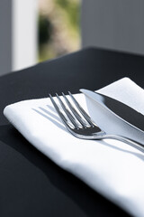 Wall Mural - Fork and knife with white napkin on table in luxury restaurant outdoors, fine dining menu for wedding or event and food catering service concept.