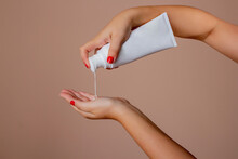 Manos Femeninas Aplican Crema Hidratante Para El Cuidado Cosmético De La Piel Aislado En El Fondo De Crema.