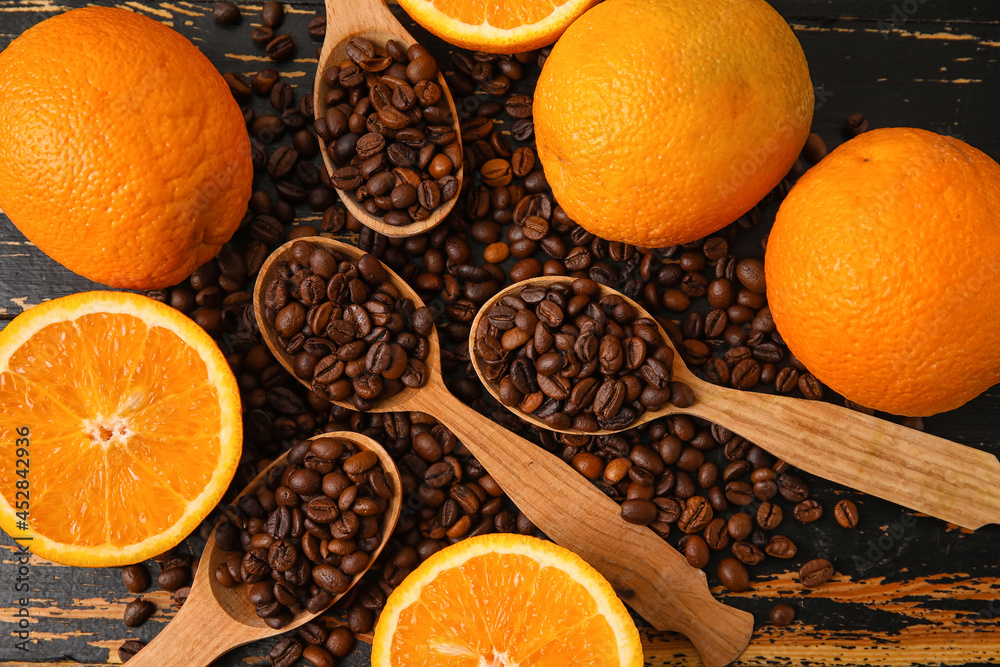 Composition with coffee beans and fresh oranges on dark wooden background
