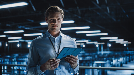 Fototapete - Portrait of Handsome Smiling IT Specialist Using Tablet Computer in Data Center, Looking at Camera. Succesful Male e-Business Engineer Working in Big Server Farm Cloud Computing Facility.