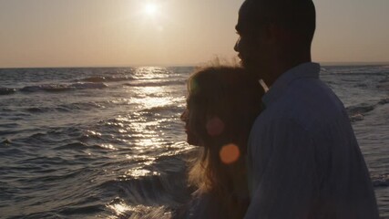 Wall Mural - Young beautiful couple in love standing and hugging on beach by the sea