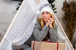 © ako-photography - Pretty blonde woman laying on Christmas giftboxes wear knitted pullover and santa hat