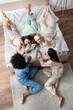 high angle view of smiling interracial women lying on bed during slumber party