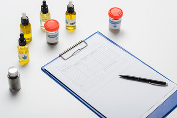 bottles and containers with medical cannabis near prescription on white desk