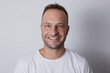 © Eanaya - Man smiling in a white background with white t-shirt