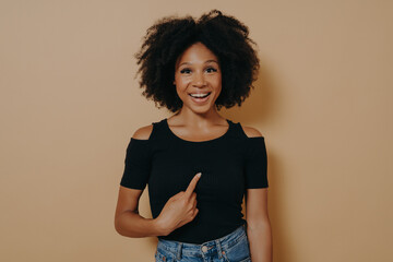 Wall Mural - Overjoyed young mixed race woman pointing finger at herself and looking at camera with amazed face expression