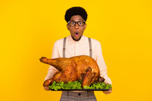 Photo Portrait Man In Glasses Keeping Baked Chicken On Thanksgiving Day Amazed Isolated Vivid Yellow Color Background