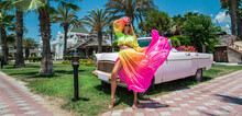 Summer Fashion. Beautiful Sexy Blonde Woman In Colorful Dress Near The Pink Car On Cuba Havana. Spring And Summer Fashion Model Concept. Vintage And Retro Style. Luxury Travel.