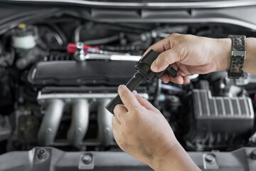 Wall Mural - Technician check old spark plug coil with Burn marks on engine coil in Maintenance service of gasoline  engine in garage