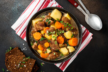 Traditional Irish Stew In A Black Bowl On A Dark Background. Stew Of Lamb, Potatoes, Onions, Carrots, And Thyme. Traditional Dish Of St. Patrick's Day.