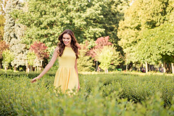 Wall Mural - Photo of young cheerful pretty woman happy positive smile walk park green trees sunny weather outdoors