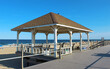 © Estrelle - Well-kept pavilion with benches on boardwalk in front of beach (sand and shore)