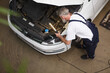 © Ihor - Top view shot of a senior male mechanic repairing engine of a car at the workshop