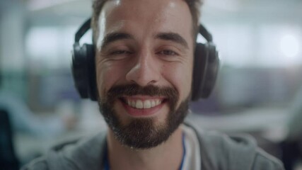 Poster - Office: Portrait of Happy IT Programmer Wearing Headphones Working on Computer, Looking at Camera and Smiling. Male Software Engineer Developing App, Video Game. Listening to Podcast, Music. Close-up