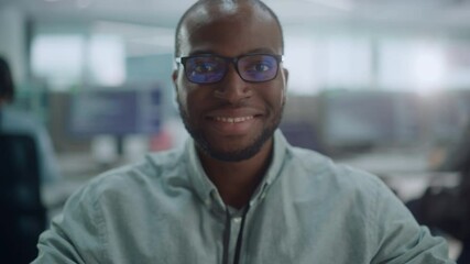 Poster - Office: Portrait of Focused IT Programmer Wearing Headphones Working on Computer, Looking at Camera and Smiling. Black Male Software Engineer Developing Innovative App, Program, Video Game. Zoom In