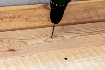 Twistdrill in an electric screwdriver on a wooden table