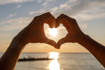 heart of love hands on the beach at sunset