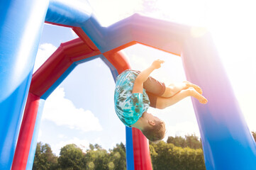 Child jumping on colorful playground trampoline. Kids jump in inflatable bounce castle on birthday party.  Horizontal childhood poster, greeting cards, headers, website.