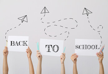 Sticker - Hands of pupils holding stationery and paper sheets with text BACK TO SCHOOL on grey background