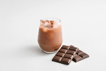 Glass of tasty chocolate milk on white background