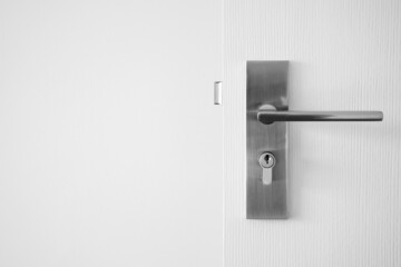 Modern door handle with keyhole on white door