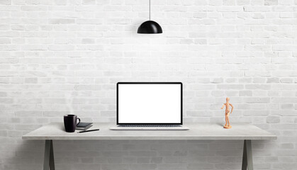 Wall Mural - Laptop mockup on work desk with coffee mug, diary, pen and figure beside. White brick wall in background. Web site presentation concept