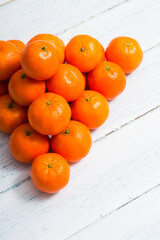 Wall Mural - pyramid stack of mandarin oranges on shabby chic white wood table background