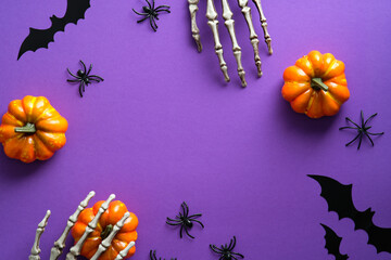 Wall Mural - Halloween decorations, pumpkins, spiders, bats on violet background. Flat lay, top view, copy space. Halloween greeting card mockup.