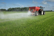 Fertilizer spreader. Fertilizer. Tractor fertilizing. Farming. Meadow. Grass. Chalk. Netherlands