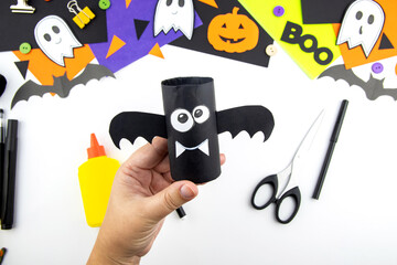 Wall Mural - Craft with a child for Halloween from rolls of toilet paper and a black paper bat. Step-by-step instruction summary.