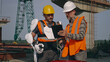 Male engineers using tablet on construction site together