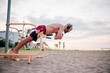 © alvaro - Man training in a calisthenics beach workout park.
