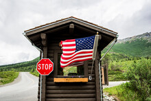 USA, Alaska, American Flag And Stop Sign On Cabin