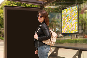 Young woman waiting for public transport at bus stop