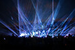 © aigarsr - blue laser lights and people silhouettes at concert