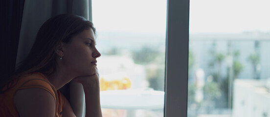 young female person looking in the window, depressed and despair feelings