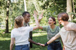 Cheerful interracial teen friends giving high five outdoors