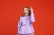 © Lustre Art Group  - Cropped portrait of young excited girl raising finger up isolated on red studio background. Concept of human emotions