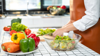 Poster - Asian housewife using knife to slice lettuce on wooden chopping board to preparing ingredients for vegetable