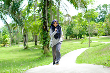 Portrait of a young muslim woman exercising and jogging outside in the park