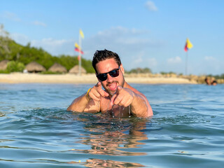 Hispanic young man posing in a tropical beach in Baru Island, Cartagena de Indias, Colombia