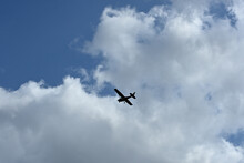 A Silhouette Of A Cessna Plane Flying Against The Blue Sky.