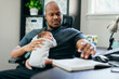 © Creative Flame - Black dad with newborn working from home