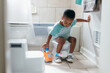 © Creative Flame - Black boy, potty training time at home, playing with toy truck