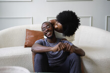 Smiling Couple Cuddling In Living Room