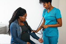 Black Woman Nurse Checks Vitals Of Pregnant Patient