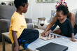© Creative Flame - African American family playing checkers game at home