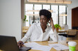 © Creative Flame - Thoughtful and focused Business woman with laptop in office, African American