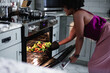 © Creative Flame - Black woman roasting healthy vegetables in oven