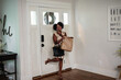 © Creative Flame - African American woman bringing home groceries, multitasking on phone, professional businesswoman